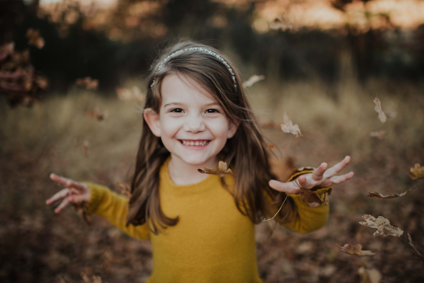 little girl laughing in leaves