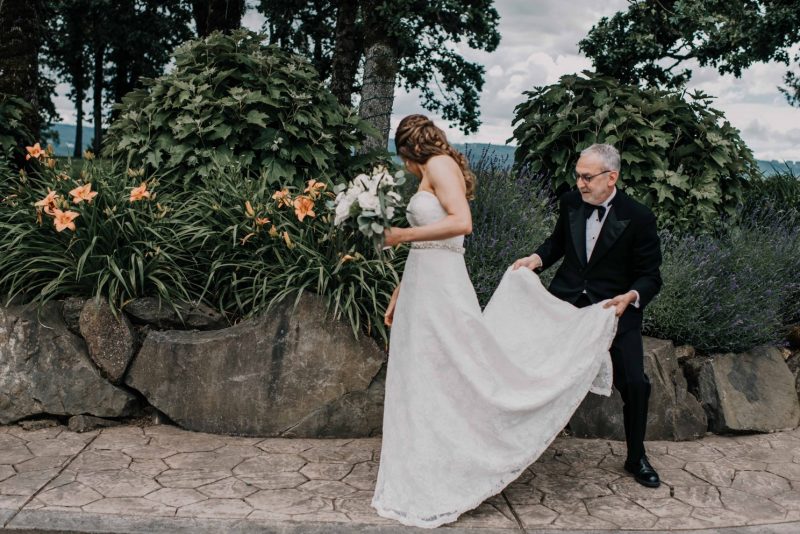 Dad helping bride with dress